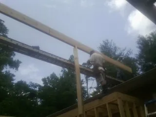 Carpenter setting a ridge beam over a new addition frame — Ice Dam Removal by Roofing Brothers in Jacks Creek