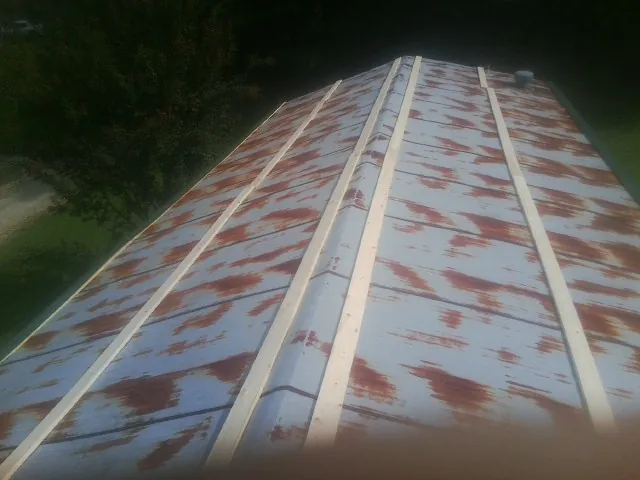 Rusted metal roof panels with new wood purlins before replacement — Storm Damage Roof Repair in Jacks Creek by Roofing Brothers