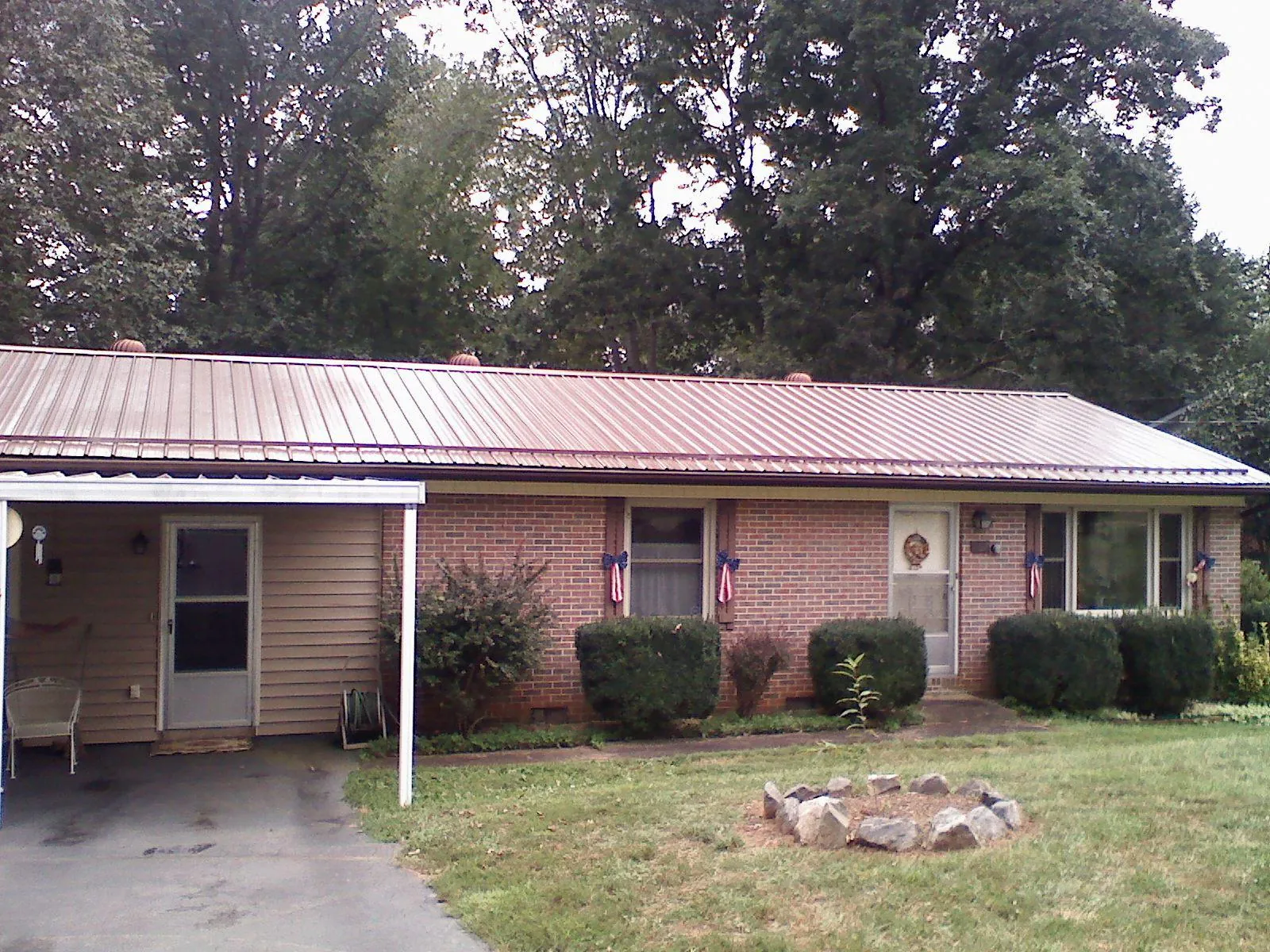 Bronze metal roof and carport on a brick ranch home — Roof Repair work by our crew in Jacks Creek