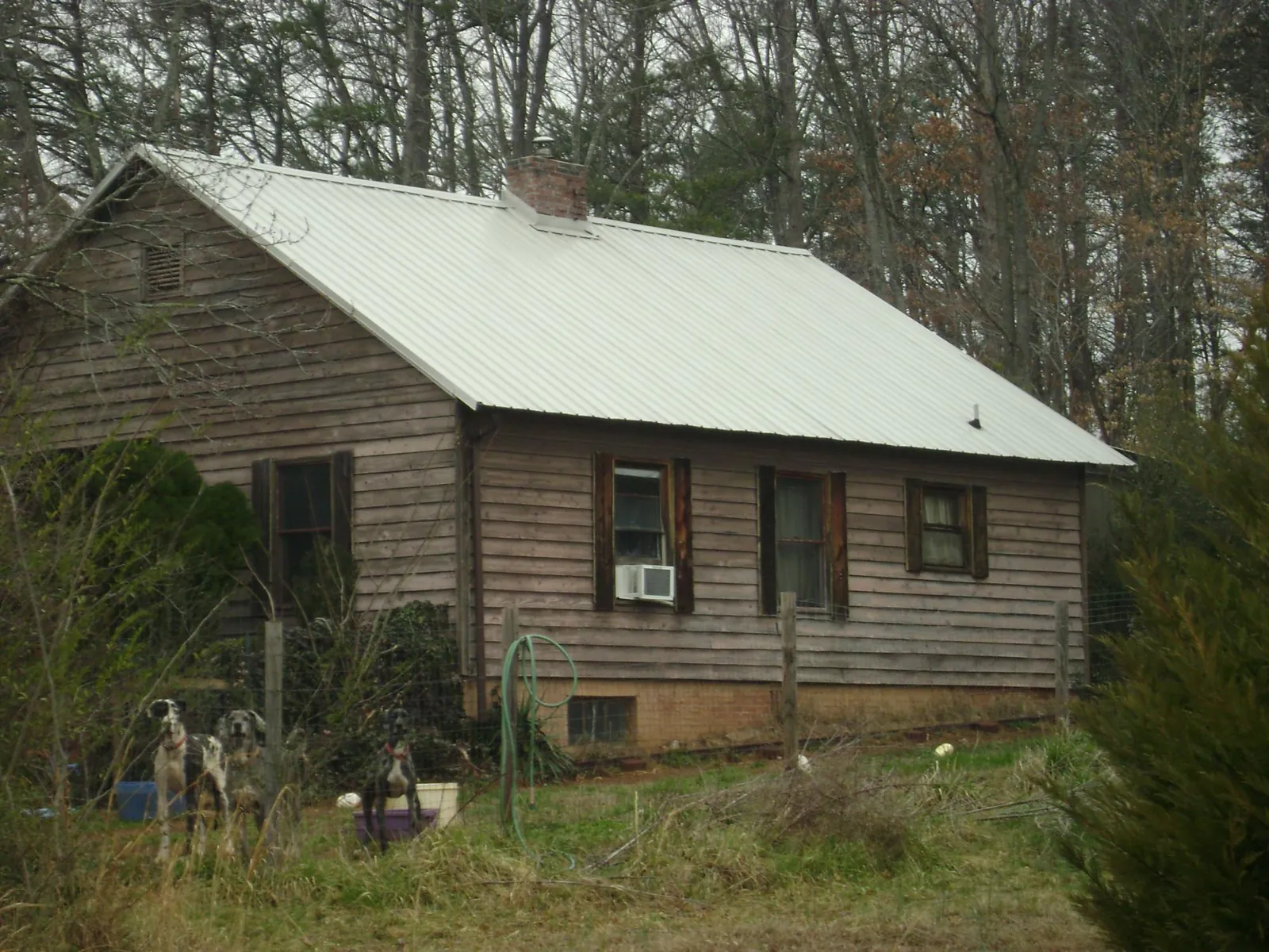 White metal roof on an old wood sided farmhouse, from a Metal Roof Installation job in Jacks Creek